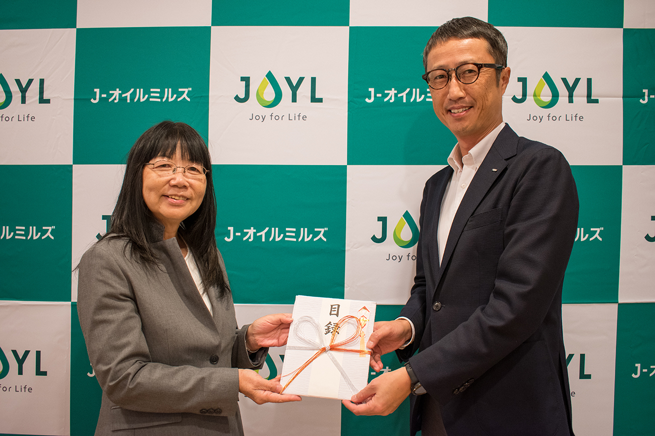 JEAN 理事 吉野美子氏（左）、当社執行役員 マーケティング統括部長 佐藤 亮（右）＝10月23日、寄付金の贈呈式を開催